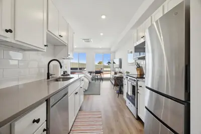 a kitchen with white cabinets and a counter top at The Commons on Ludlow in Philadelphia
