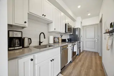 a kitchen with white cabinets and stainless steel appliances at The Commons on Ludlow in Philadelphia
