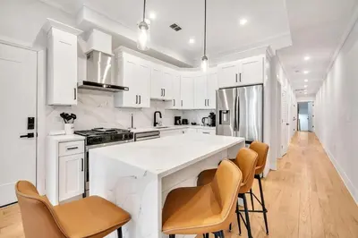 a kitchen with white cabinets and a large white island at Modern Luxury 3BR 2BA 10 minutes to NYC in Weehawken