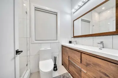 a bathroom with a toilet and a sink and a mirror at Modern Luxury 3BR 2BA 10 minutes to NYC in Weehawken