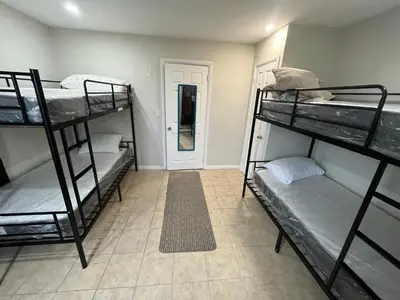 a room with three bunk beds and a hallway at Modern Oasis in Bayonne