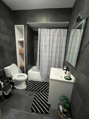 a bathroom with a white toilet and a sink at Modern Oasis in Bayonne