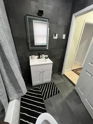 a bathroom with a sink and a mirror at Modern Oasis in Bayonne