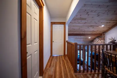 a hallway with a door and a staircase with wooden floors at Luxury House in Pocono Mountains in Tannersville