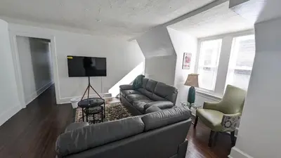a living room with a couch and a flat screen tv at Rooftop GreeneHouse Suite in Philadelphia
