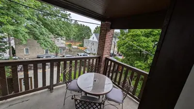 a balcony with a table and chairs and a view of a street at Rooftop GreeneHouse Suite in Philadelphia