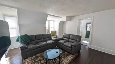 a living room with a leather couch and a table at Rooftop GreeneHouse Suite in Philadelphia
