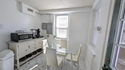 a small white room with a table and a microwave at Rooftop GreeneHouse Suite in Philadelphia