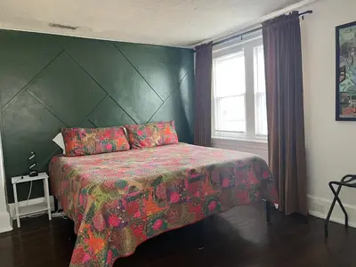 a bedroom with a large bed with a green wall at Rooftop GreeneHouse Suite in Philadelphia