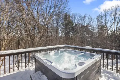 a hot tub on a deck in the snow at Secluded 9BR Getaway, Pool, Hot Tub & Huge Deck in Chester