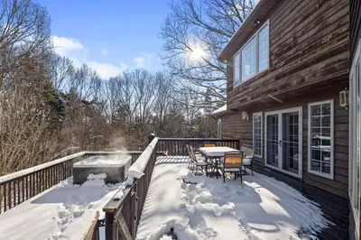 a deck with a grill and a table in the snow at Secluded 9BR Getaway, Pool, Hot Tub & Huge Deck in Chester
