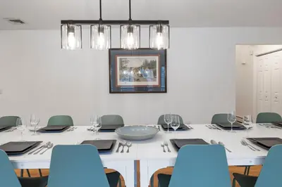 a dining room with a white table and blue chairs at Secluded 9BR Getaway, Pool, Hot Tub & Huge Deck in Chester
