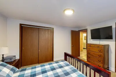 a bedroom with a bed and a flat screen tv at Hot Tub, Dock, Pool Table! Lakefront Poconos Haven in White Haven