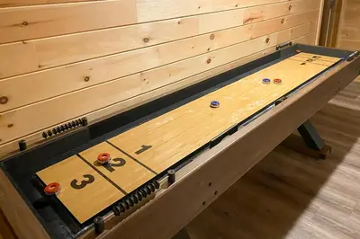 a wooden shuffleboard table in a room at Hot Tub, Dock, Pool Table! Lakefront Poconos Haven in White Haven