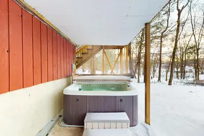 a jacuzzi tub in a building in the snow at Hot Tub, Dock, Pool Table! Lakefront Poconos Haven in White Haven