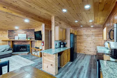 a kitchen with wooden walls and wooden flooring in a log cabin at Hot Tub, Dock, Pool Table! Lakefront Poconos Haven in White Haven
