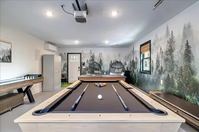 a ping pong table in a room with a wall with trees at Luxury Hot Tub Sauna Game Room Dog Friendly in Albrightsville