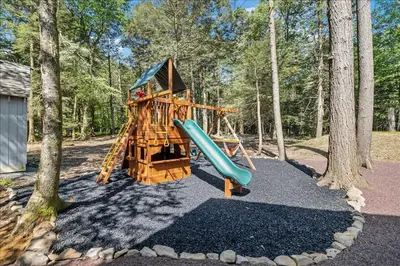 a playground with a slide in the woods at Luxury Hot Tub Sauna Game Room Dog Friendly in Albrightsville