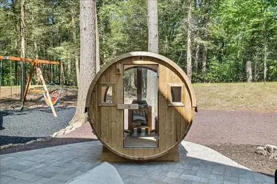 a small wooden circular building next to a playground at Luxury Hot Tub Sauna Game Room Dog Friendly in Albrightsville