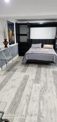 a bedroom with a bed and a wooden floor at Staycation Oasis! a unique Experience! Heated pool open until November 1st in Easton