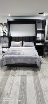 a bedroom with a large bed with a wooden floor at Staycation Oasis! a unique Experience! Heated pool open until November 1st in Easton