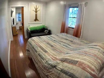a bedroom with a bed and a chair and a window at Roscoe Pine House in Roscoe