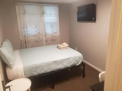 a small room with a bed and a television at Orchard Room by the Airport - Shared Space in Darby