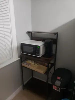 a microwave oven sitting on a shelf next to a window at Orchard Room by the Airport - Shared Space in Darby