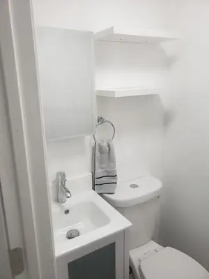 a white bathroom with a sink and a toilet at Orchard Room by the Airport - Shared Space in Darby