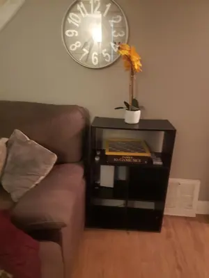 a table with a couch and a clock on the wall at Orchard Room by the Airport - Shared Space in Darby