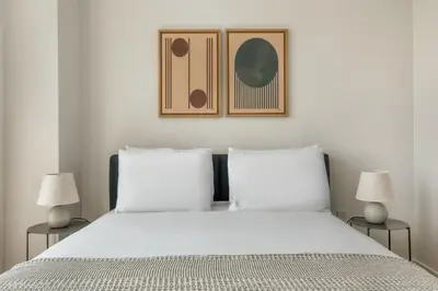 a bedroom with a large white bed with two lamps at Blueground LES gym doorman near market NYC-1523 in New York