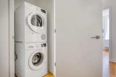 a washer and dryer in a white laundry room at Blueground LES gym doorman near market NYC-1523 in New York