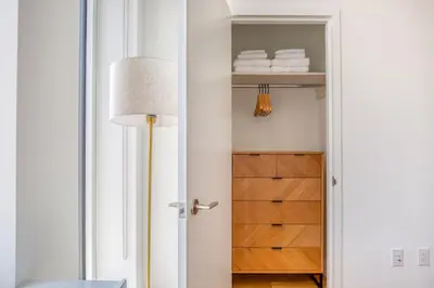 a room with a closet with a lamp and towels at Blueground LES gym doorman near market NYC-1523 in New York