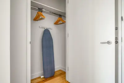 a surfboard hanging in a closet with two lights at Blueground LES gym doorman near market NYC-1523 in New York