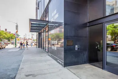 a building on a city street with people walking on the sidewalk at Blueground LES gym doorman near market NYC-1523 in New York