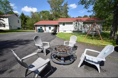 a group of chairs and a circular table in front of a house at Cozy home away from home in Tobyhanna