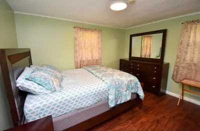 a bedroom with a bed and a dresser and a mirror at Cozy home away from home in Tobyhanna