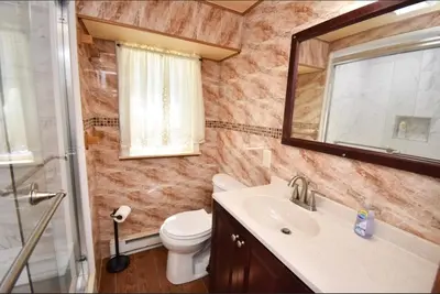 a bathroom with a sink and a toilet and a mirror at Cozy home away from home in Tobyhanna