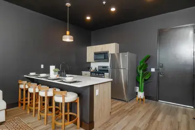 a kitchen with a large island with bar stools at Cozy 1 King BR, Gym, Free Parking, 8mins Train in East Orange