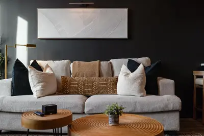 a living room with a gray couch with pillows at Cozy 1 King BR, Gym, Free Parking, 8mins Train in East Orange