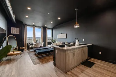a kitchen with a sink and a living room at Cozy 1 King BR, Gym, Free Parking, 8mins Train in East Orange