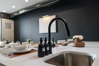 a kitchen counter with a sink with wine bottles on it at 2BR 2BA, King bd, Gym, Free Parking, 8min to Train in East Orange