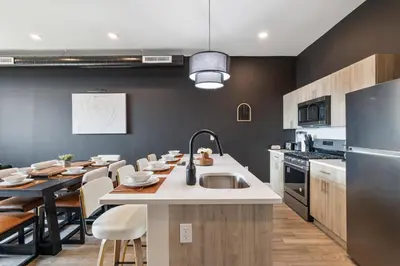 a kitchen with a sink and a table with chairs at 2BR 2BA, King bd, Gym, Free Parking, 8min to Train in East Orange