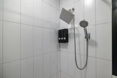 a shower with a shower head in a bathroom at 2BR 2BA, King bd, Gym, Free Parking, 8min to Train in East Orange