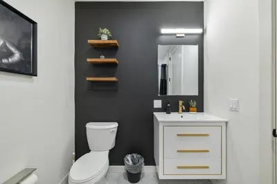 a bathroom with a white toilet and a mirror at 2BR, King Bd, Free Prkn, Gym, NYC View, 8min Train in East Orange