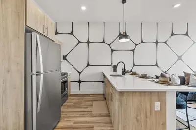 a kitchen with a stainless steel refrigerator and wooden cabinets at King Bd, Free Prkn, NYC View, 8min Train in East Orange