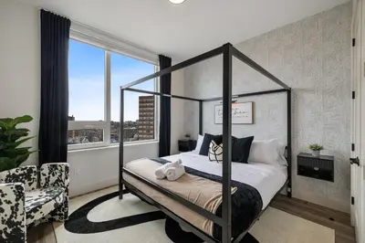 a bedroom with a canopy bed in front of a window at King Bd, Free Prkn, NYC View, 8min Train in East Orange