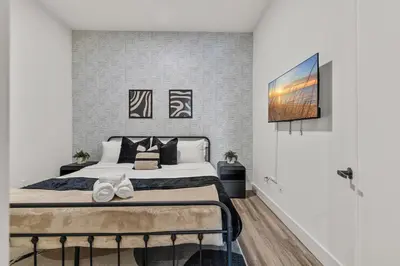 a bedroom with a bed and a tv on a wall at King Bd, Free Prkn, NYC View, 8min Train in East Orange