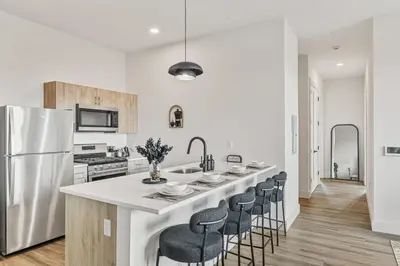 a kitchen with a large white island with bar chairs at Upscale Views 2br Free Parkn, Walk 2 Train, 2bath in East Orange