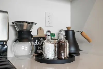 a table with bottles and a blender and a keyboard at Upscale Views 2br Free Parkn, Walk 2 Train, 2bath in East Orange